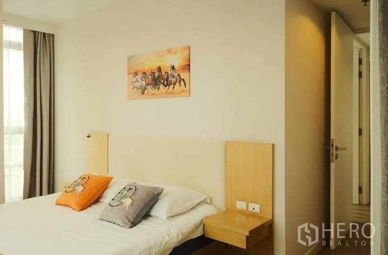 Condominium for rent in Bang Rak, Bangkok - Master bedroom with bedside shelves and sunset horse artwork.