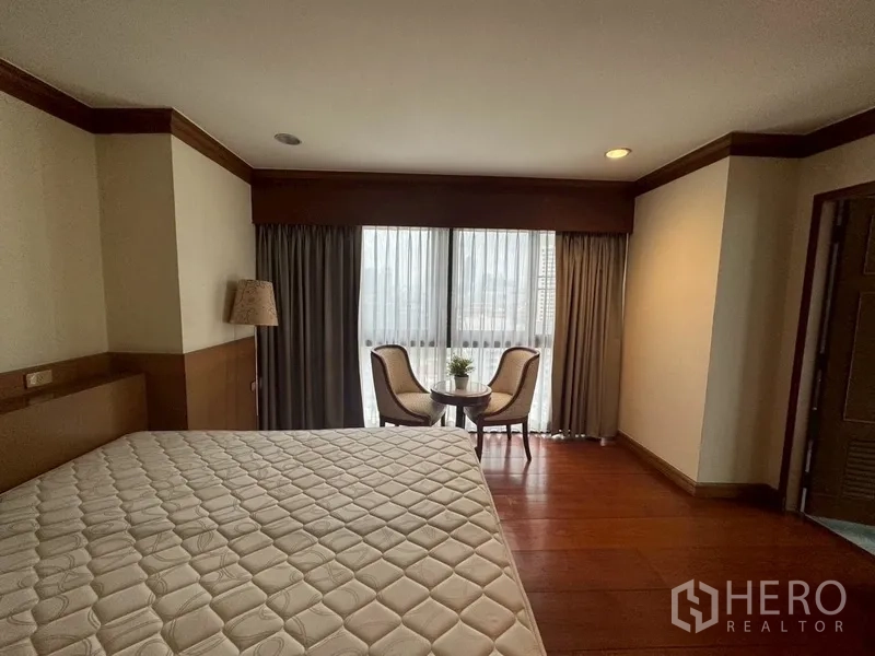 Condominium for rent in Watthana, Bangkok - Bedroom window corner with two chairs and a round table.