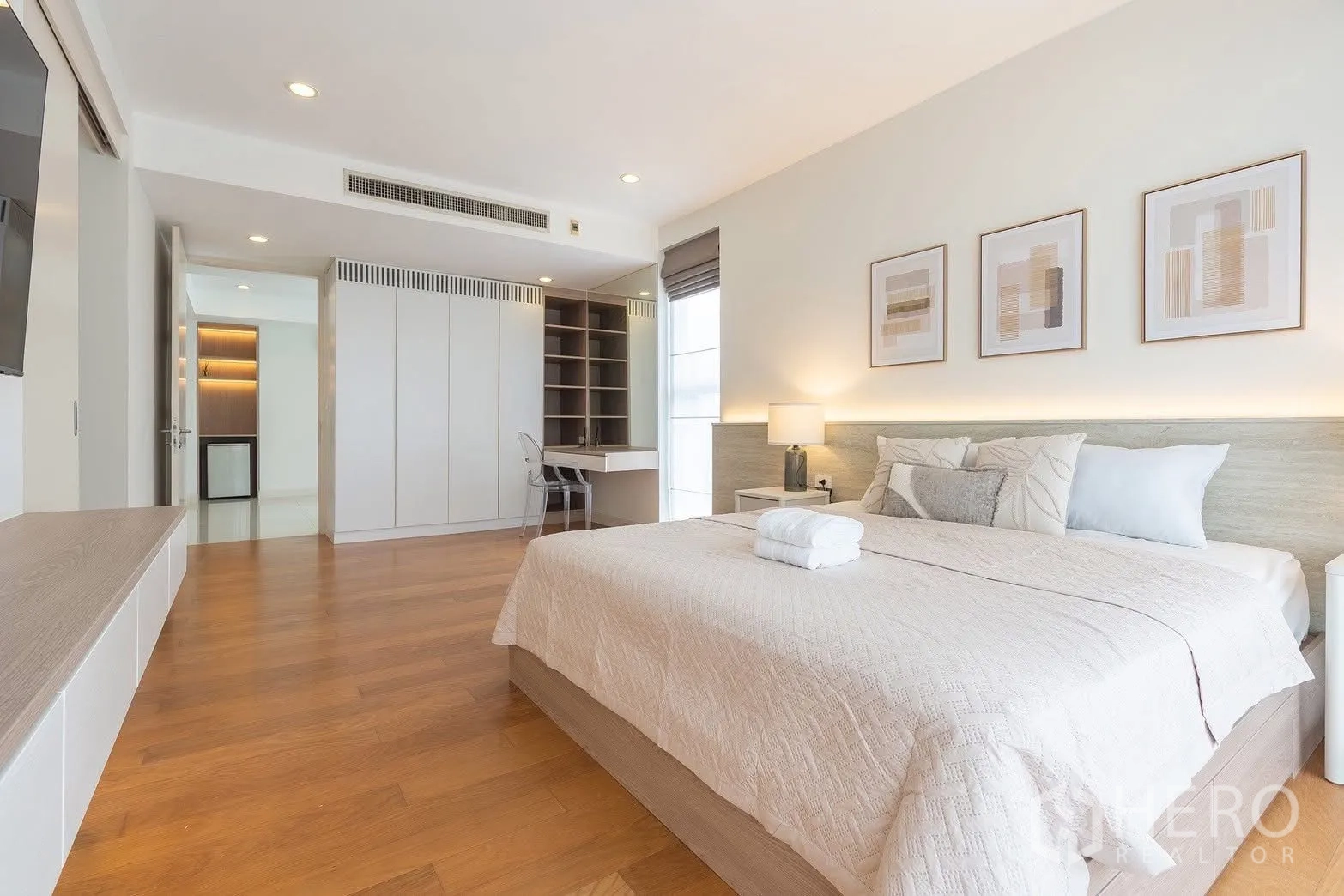 Detached House for rent in Saphan Sung, Bangkok - Master bedroom with built-in cabinetry, study nook, and wood floors.