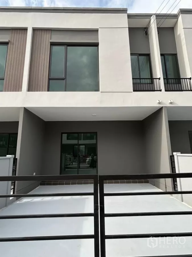 Townhouse for rent in Bang Phli, Samut Prakan - Modern two-storey townhouse facade with covered carport and sliding gate.
