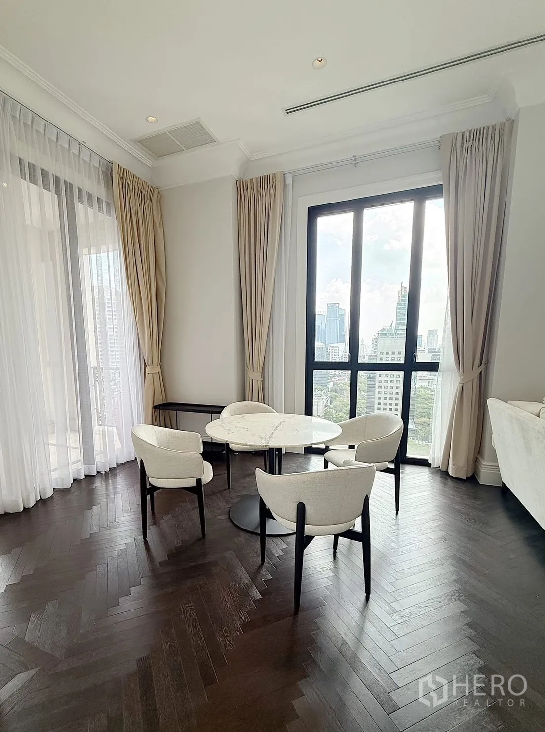 คอนโด for rent or sale in Pathum Wan, Bangkok - มุมรับประทานอาหารโต๊ะหินอ่อนทรงกลมพร้อมเก้าอี้สี่ตัวข้างหน้าต่างเต็มความสูง