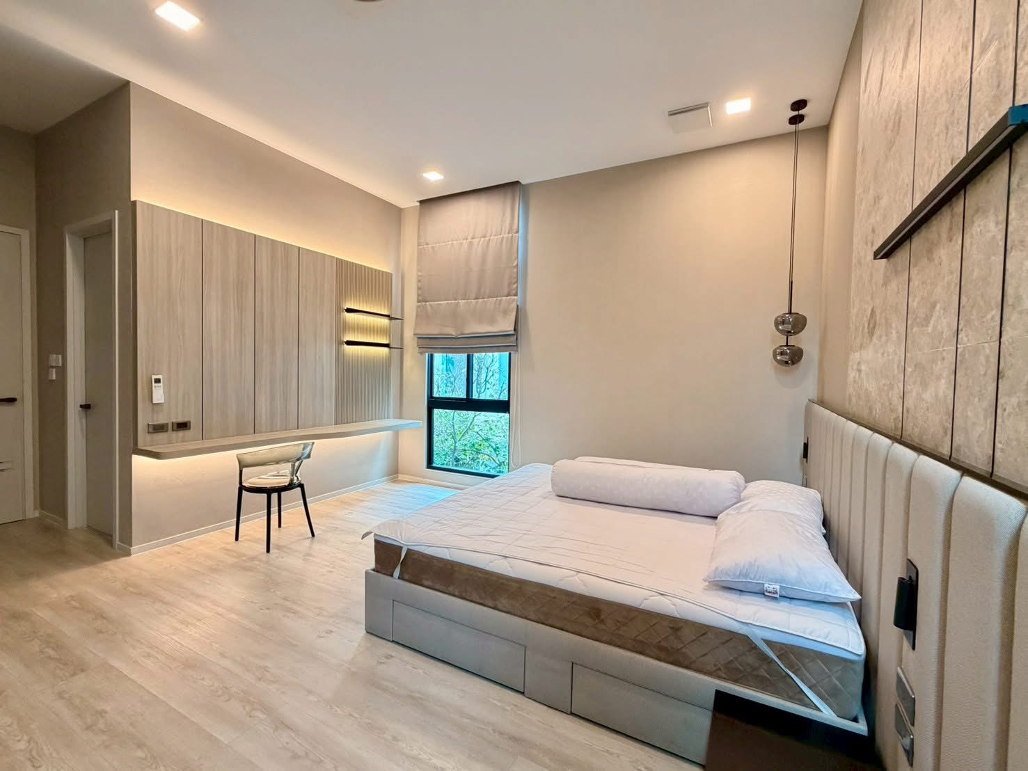 Detached House for rent in Saphan Sung, Bangkok - Bright master bedroom with upholstered headboard, built-in cabinets and a floating desk beside a large window.