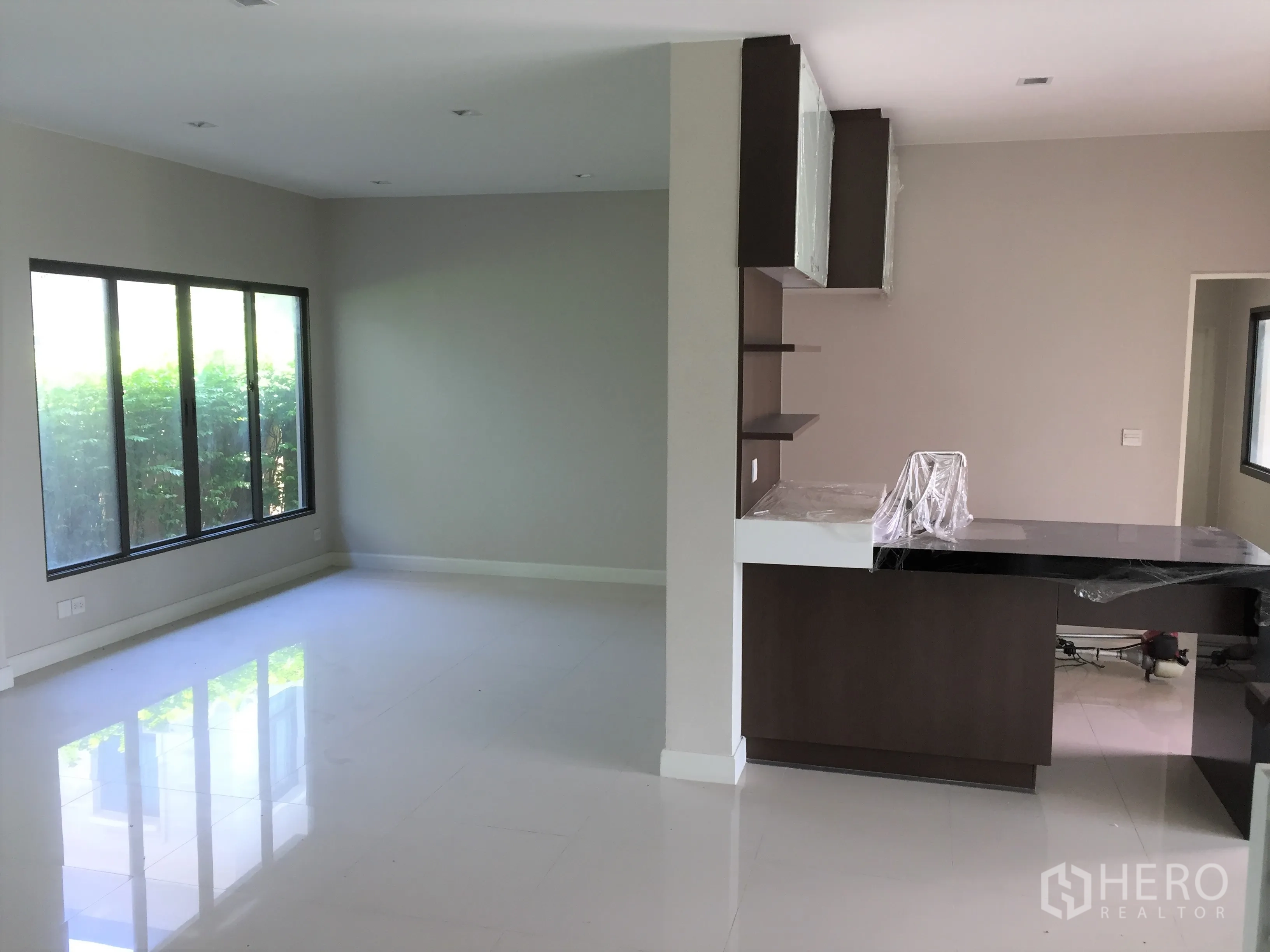 独立式住宅 出租或出售在Prawet, Bangkok - 开放式客餐厅，落地窗与吧台分区。