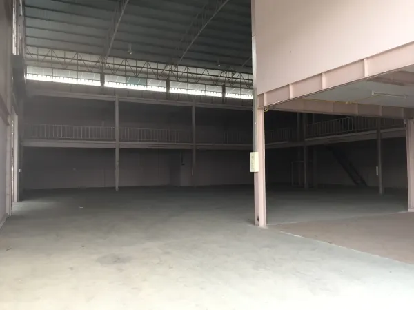Factory for rent in Lam Luk Ka, Pathum Thani - Open factory floor with steel truss roof and wraparound mezzanine walkways.