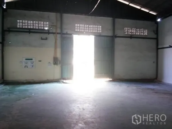 Warehouse for rent in Bang Sao Thong, Samut Prakan - Large metal double doors letting daylight into the warehouse entry area.