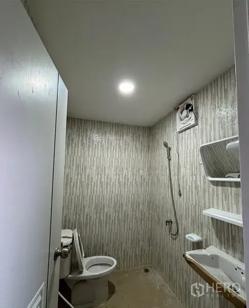 Warehouse for rent in Mueang Pathum Thani, Pathum Thani - Compact bathroom with toilet, shower, wall tiles, mirror and shelving.