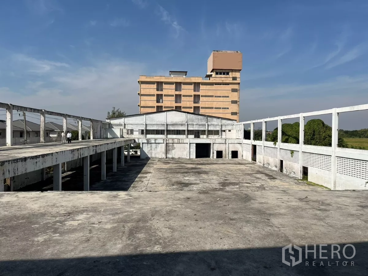 Factory for sale in Bang Phli, Samut Prakan - Expansive upper concrete deck and central warehouse yard with office block in background.