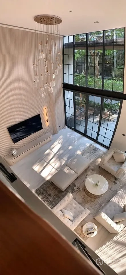 ทาวน์เฮาส์ for rent or sale in Watthana, Bangkok - มุมมองจากชั้นลอยลงสู่ห้องนั่งเล่นสว่างและหน้าต่างสูง