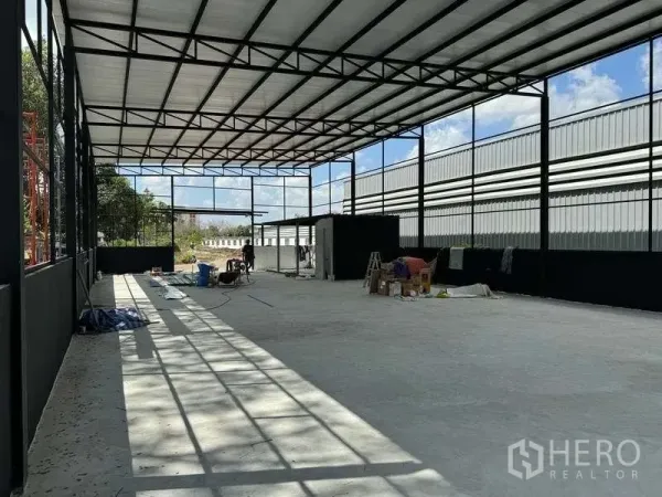 Warehouse for rent in Mueang Pathum Thani, Pathum Thani - Spacious interior bay showing truss roof, natural light and smooth concrete slab.