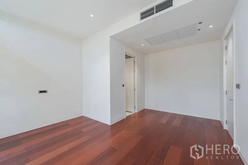 คอนโด ขายในWatthana, Bangkok - ห้องกว้างพื้นไม้โทนแดง มีช่องลมแอร์บนเพดาน และทางเข้าพื้นที่เก็บของหรือห้องแต่งตัว
