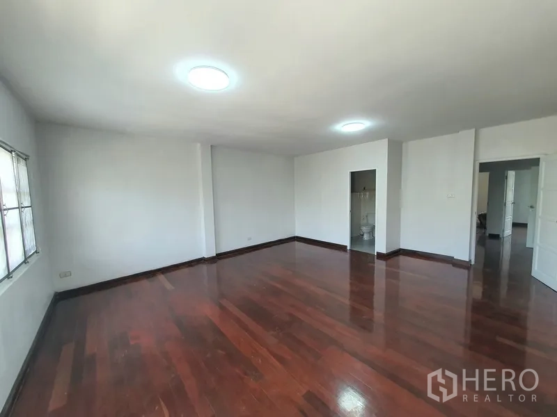 联排别墅 出售在Khlong Toei, Bangkok - 宽敞主卧，木地板，带套内浴室入口。