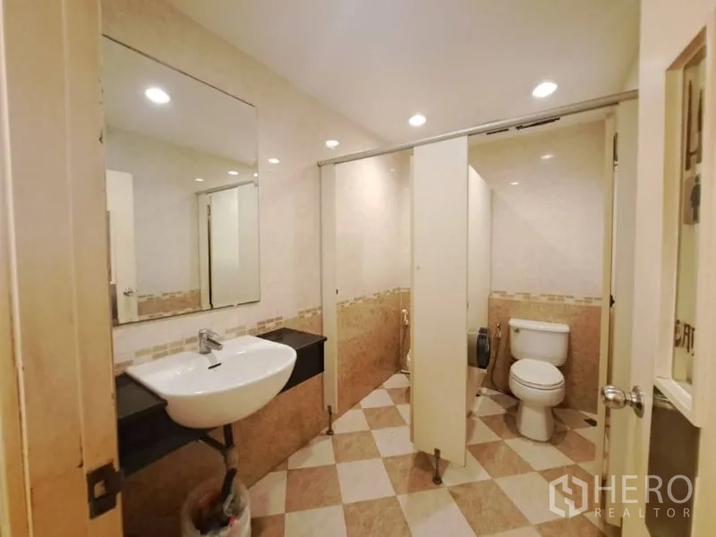 Shophouse for rent in Watthana, Bangkok - Restroom with sink, toilet stalls and checkered tile flooring.
