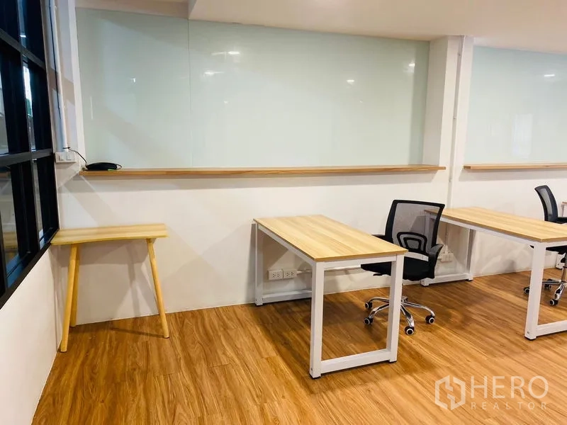 Office Space for rent in Bang Rak, Bangkok - Bright work area with desks, task chair and writable glass panel.