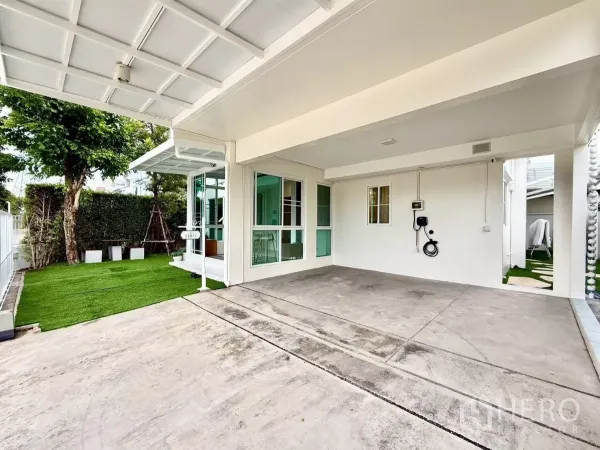 บ้าน ให้เช่าในBang Phli, Samut Prakan - โรงจอดรถในร่มพร้อมที่ชาร์จรถยนต์ไฟฟ้า ข้างสนามหญ้าและประตูกระจก