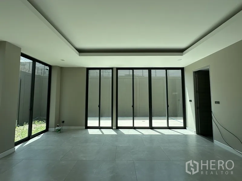家庭办公室 for rent or sale in Suan Luang, Bangkok - 采光充足的开放式房间，整面落地推拉门通向庭院与小草坪。