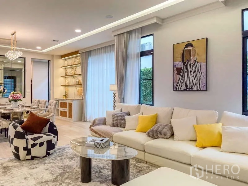 Detached House for rent in Saphan Sung, Bangkok - Living area detail showing artwork, display shelves and a cream sectional sofa.