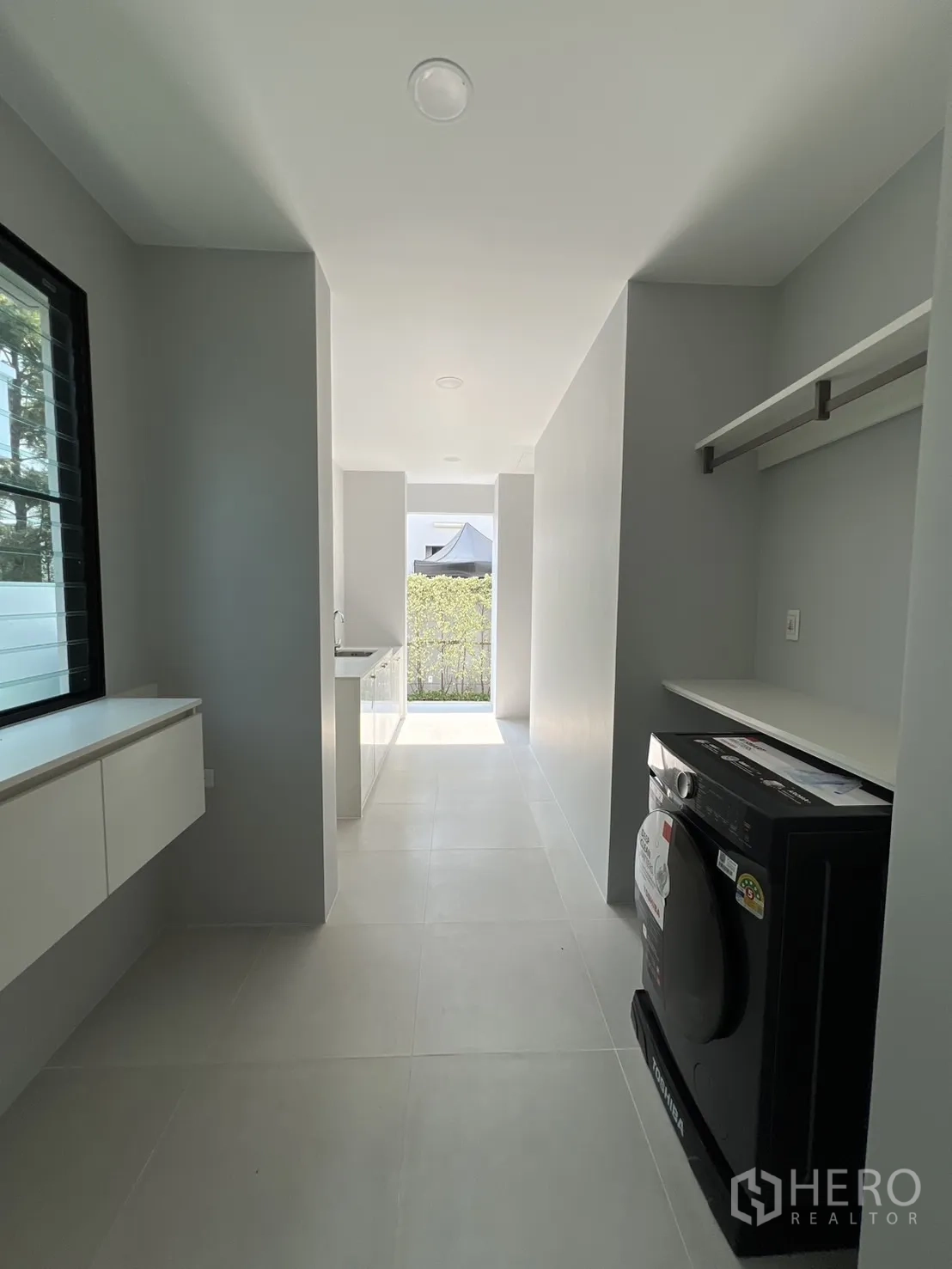Detached House for rent in Saphan Sung, Bangkok - Laundry and utility corridor with washing machine and storage.
