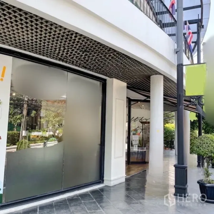Office Space for rent in Khlong Toei, Bangkok - Ground-floor corner unit showing frosted glass panels, white columns and a latticed ceiling detail.