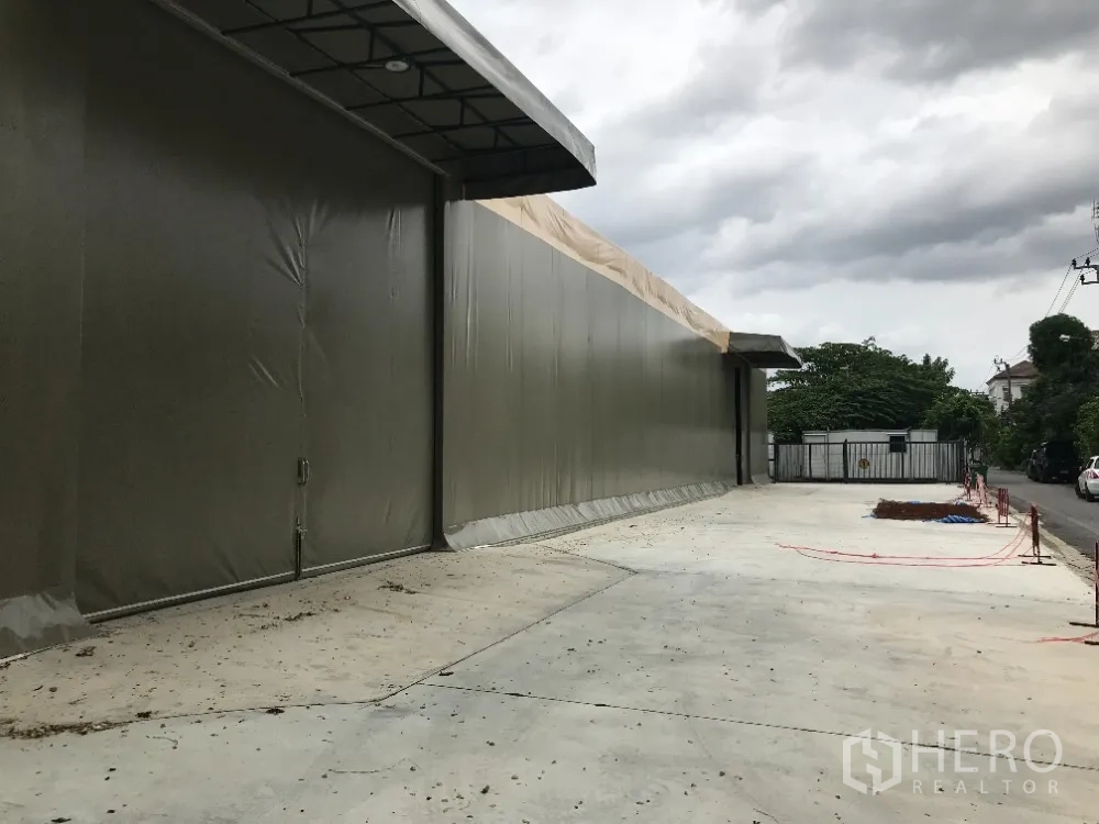 仓库 for rent in Huai Khwang, Bangkok - 仓库外立面沿街而建，带雨篷边与宽阔混凝土场地。
