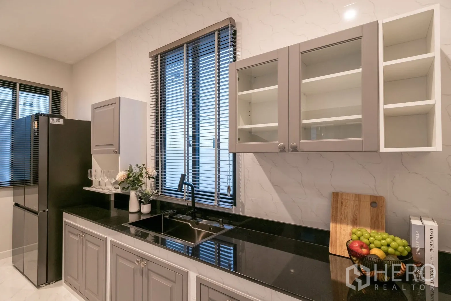 Detached House for rent or sale in Saphan Sung, Bangkok - Modern kitchen with grey cabinets, black countertop and windows.