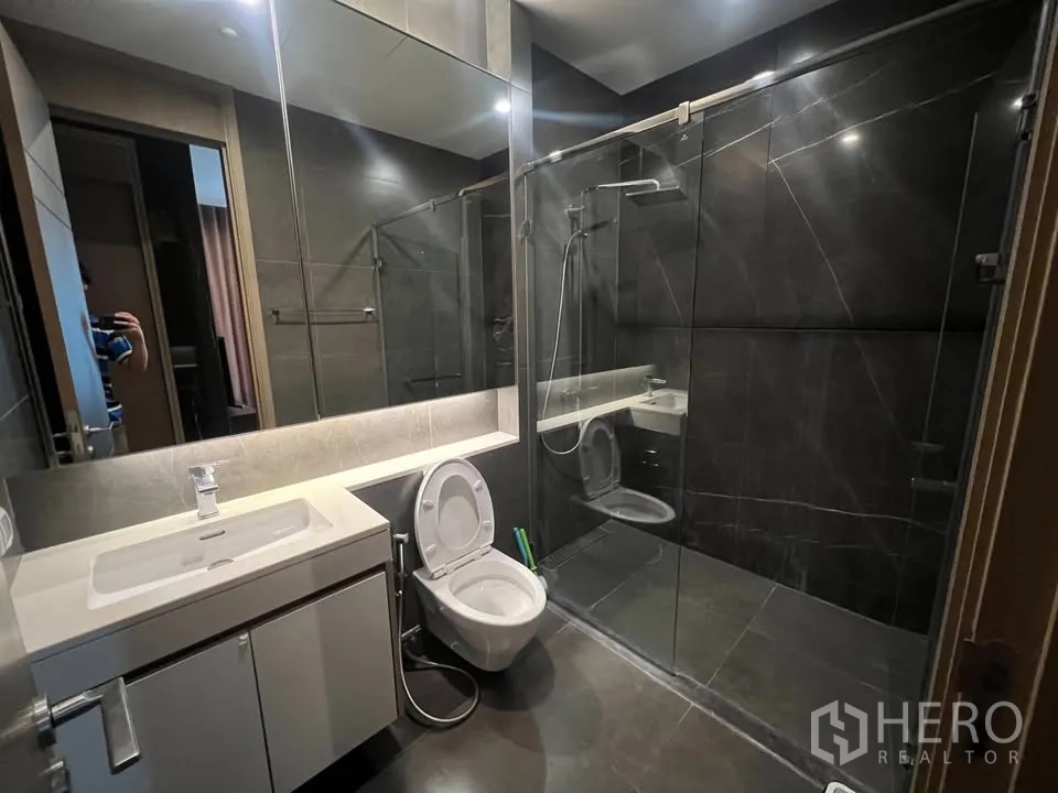 公寓 出租在Huai Khwang, Bangkok - 第二卫浴配大镜、洗手台与玻璃淋浴区。