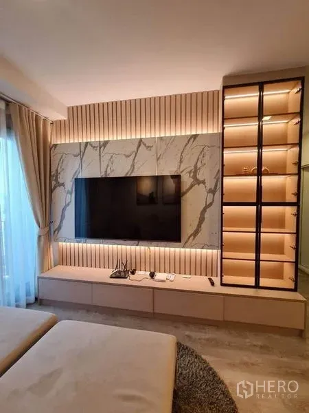 Condominium for rent - Modern living room with marble TV wall, LED lighting and glass display shelves at The Tree Pattanakarn–Ekkamai.