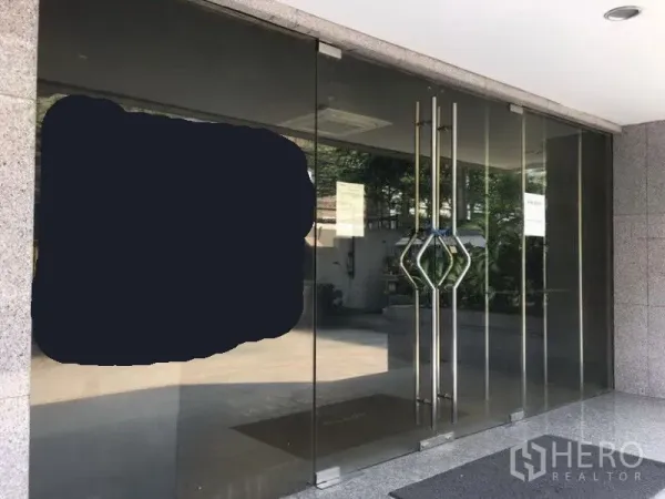 Office Space for rent in Pathum Wan, Bangkok - Glass-fronted office entrance with double stainless-steel handles at a commercial building.