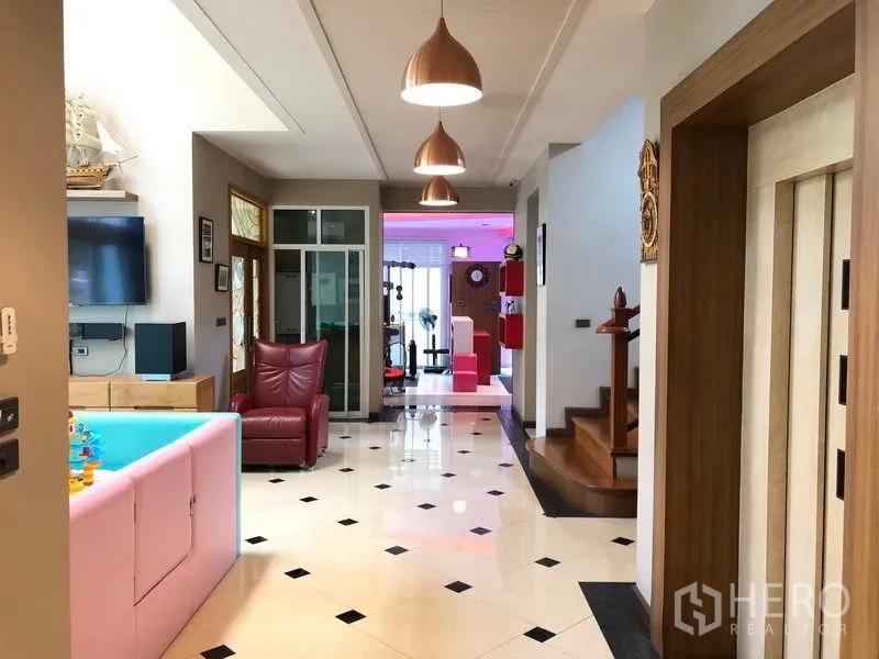 Detached House for sale in Wang Thonglang, Bangkok - Hallway view toward the gym with lounge seating and a children’s play tub.