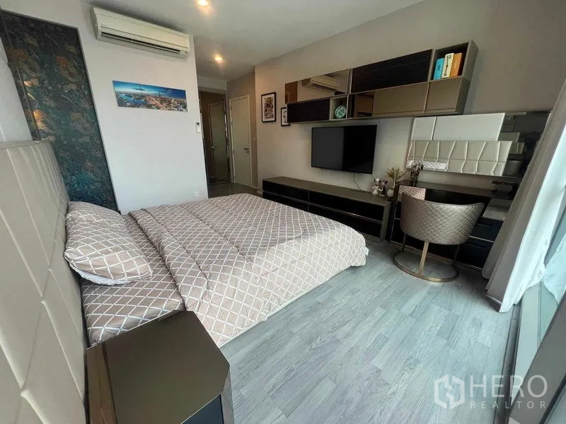Condominium for rent in Khlong Toei, Bangkok - Second bedroom with built-in desk, shelving and a wide window for natural light.