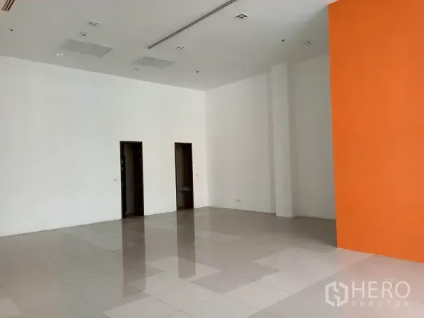 Retail Space for rent in Khlong Toei, Bangkok - Open-plan retail space with orange feature wall and two back-room doorways.