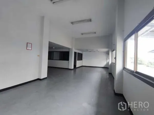 Warehouse for rent in Samut Sakhon - Bright office space with large windows and overhead lights inside the warehouse complex.