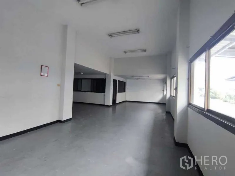 Warehouse for rent in Samut Sakhon - Bright office space with large windows and overhead lights inside the warehouse complex.