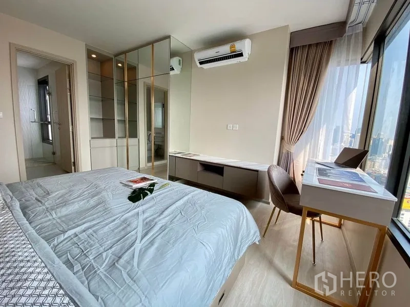公寓 出租在Pathum Wan, Bangkok - 卧室一角，镜面衣柜、内置书桌，并可通往浴室。