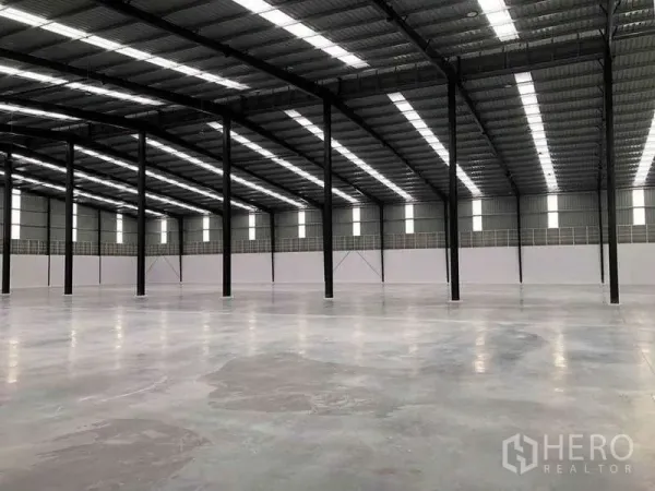 货栈 出租或出售在Nikhom Phatthana, Rayong - 仓库内成排黑色钢柱与天窗，宽大的作业空间。