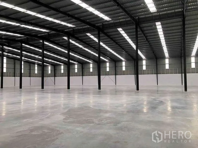 货栈 出租或出售在Nikhom Phatthana, Rayong - 仓库内成排黑色钢柱与天窗，宽大的作业空间。