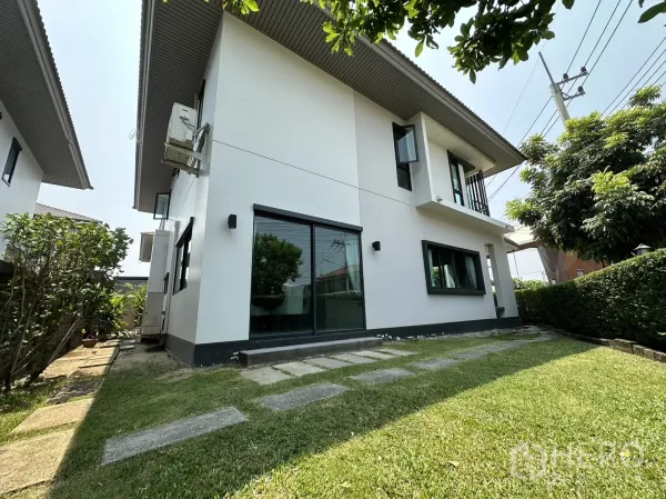 Detached House for rent or sale in Lam Luk Ka, Pathum Thani - Side garden with lawn, stepping stones and sliding glass door.