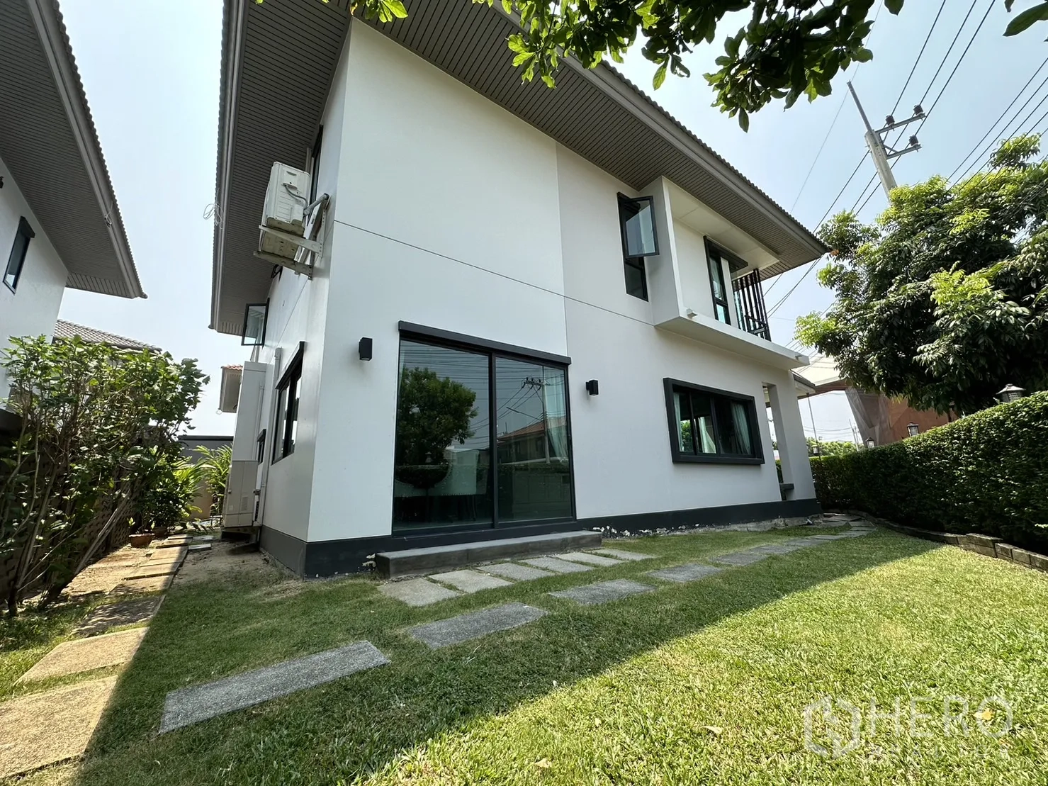 Detached House for rent or sale in Lam Luk Ka, Pathum Thani - Side garden with lawn, stepping stones and sliding glass door.