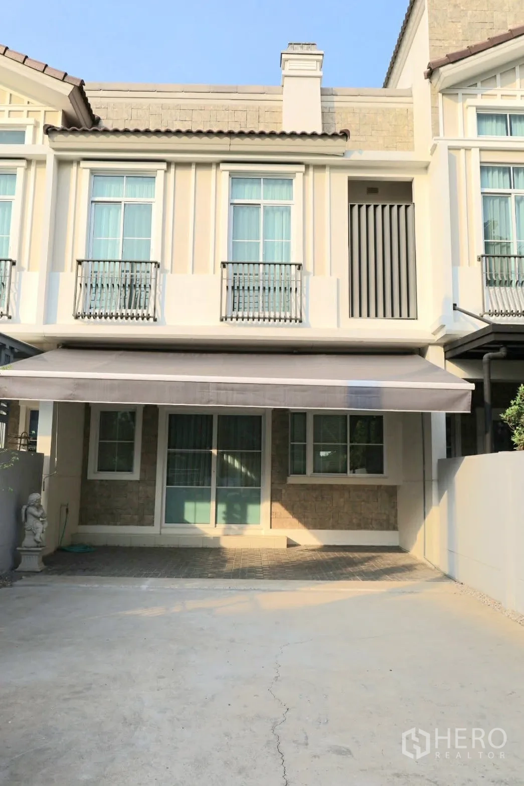 联排别墅 for rent in Prawet, Bangkok - 联排别墅外立面，法式栏杆、遮阳篷与车道车位。