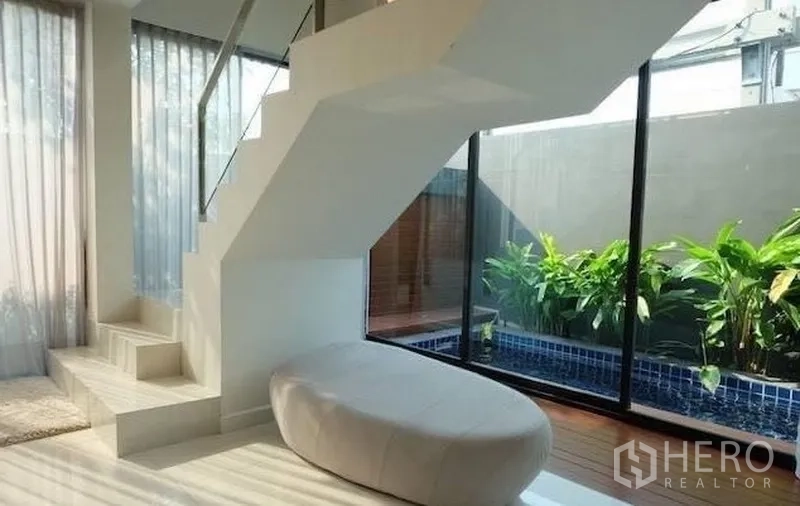 联排别墅 出租在Watthana, Bangkok - 楼梯旁对着私家浸泡池与绿植的玻璃墙景观
