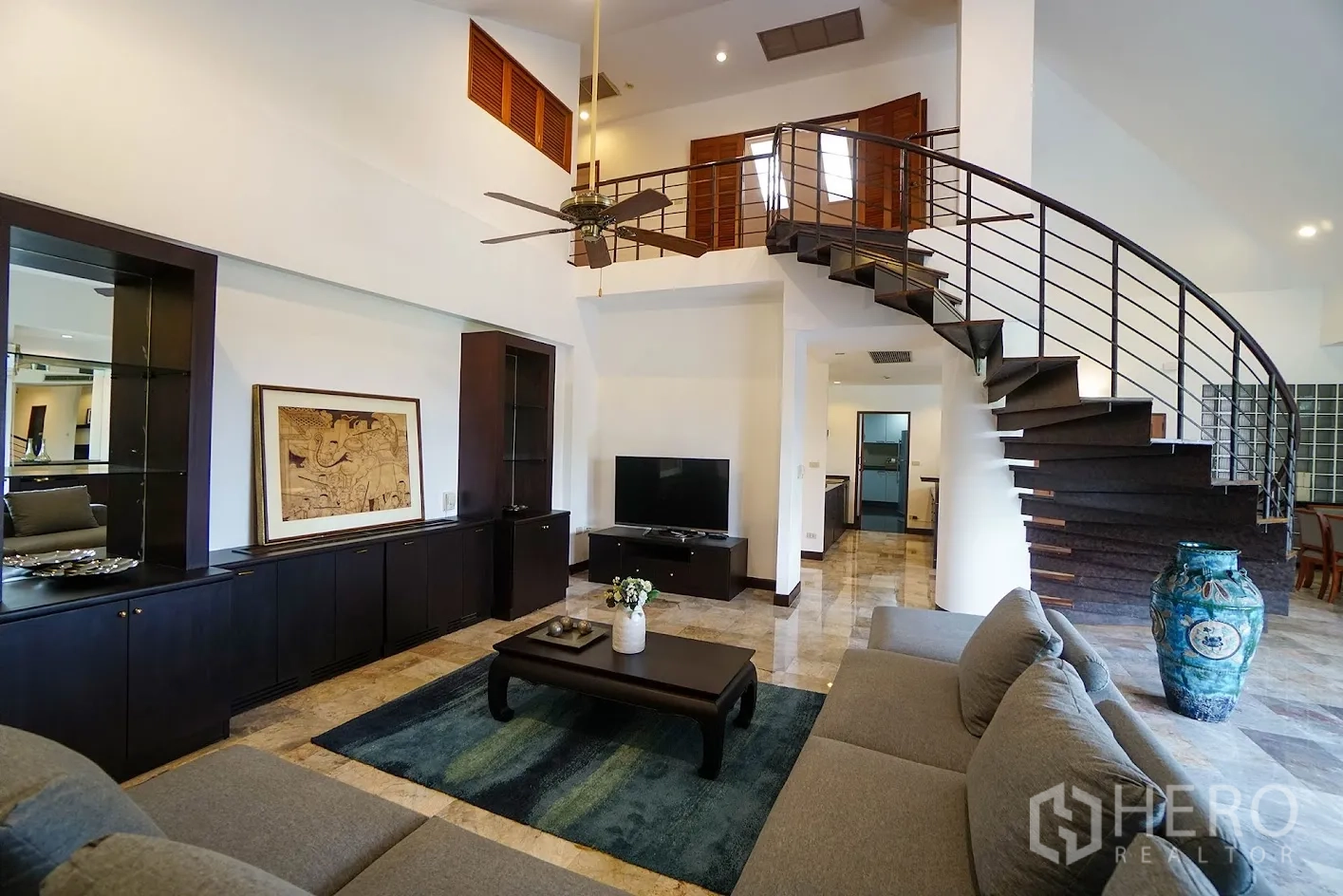 公寓 for rent in Watthana, Bangkok - 复式客厅，配弧形楼梯、吊扇、转角沙发、内置柜与电视柜。