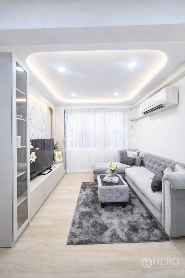 บ้านเดี่ยว for rent in Huai Khwang, Bangkok - ห้องนั่งเล่นโซฟาตัวแอล ตู้ทีวี ฝ้าหลุมไฟดาวน์ไลท์ และพรม