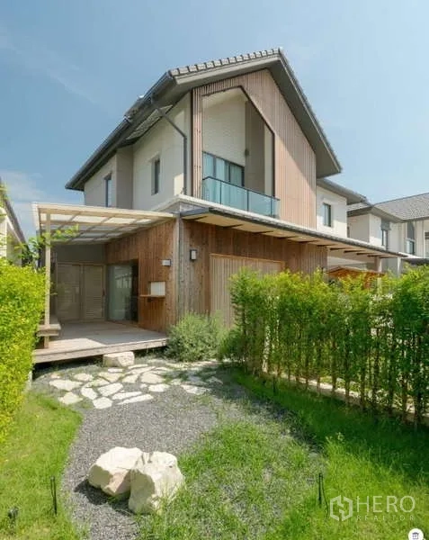 Detached House for sale in Bang Phli, Samut Prakan - Modern two-storey detached house with wood accents, balcony, and hedged front garden in Bang Phli.