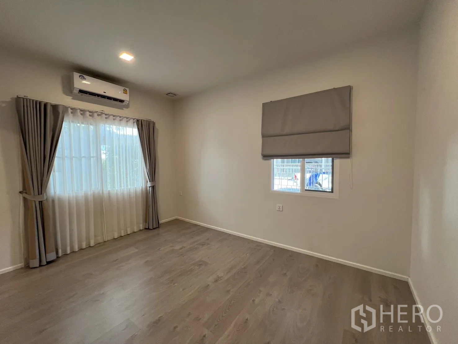 独立式住宅 出租在Prawet, Bangkok - 卧室另一角度，双窗与柔和窗帘。