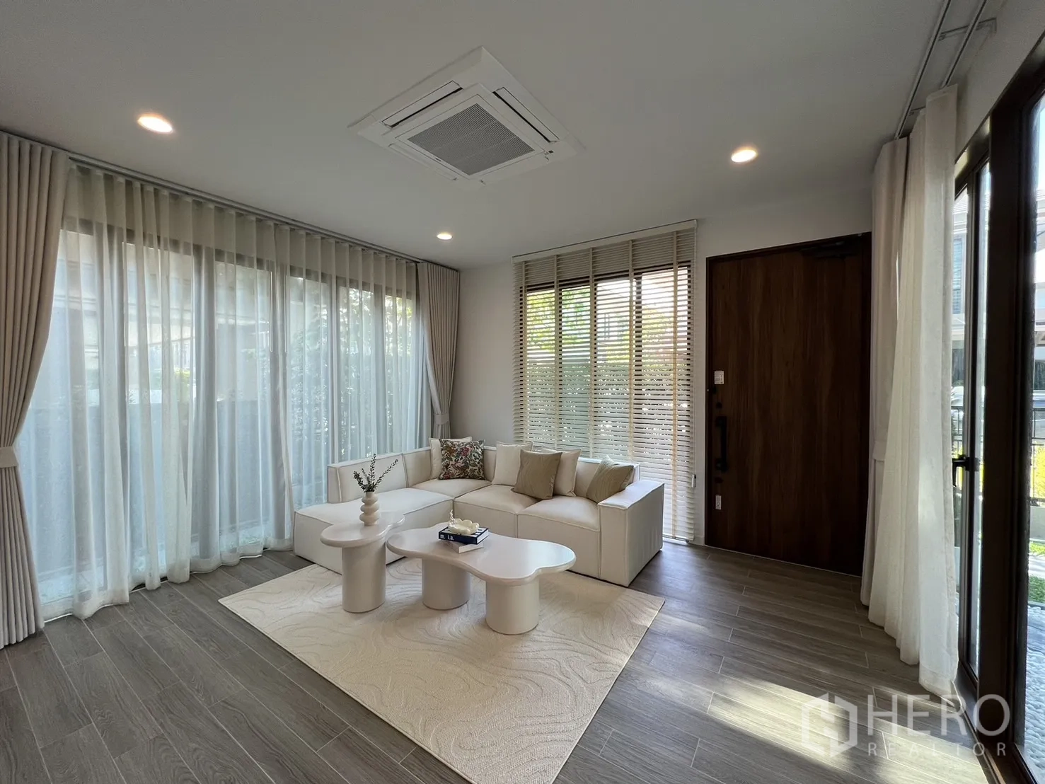 独立式住宅 出租或出售在Bang Kapi, Bangkok - 宽敞起居区，整面高窗、木门与筒灯照明。
