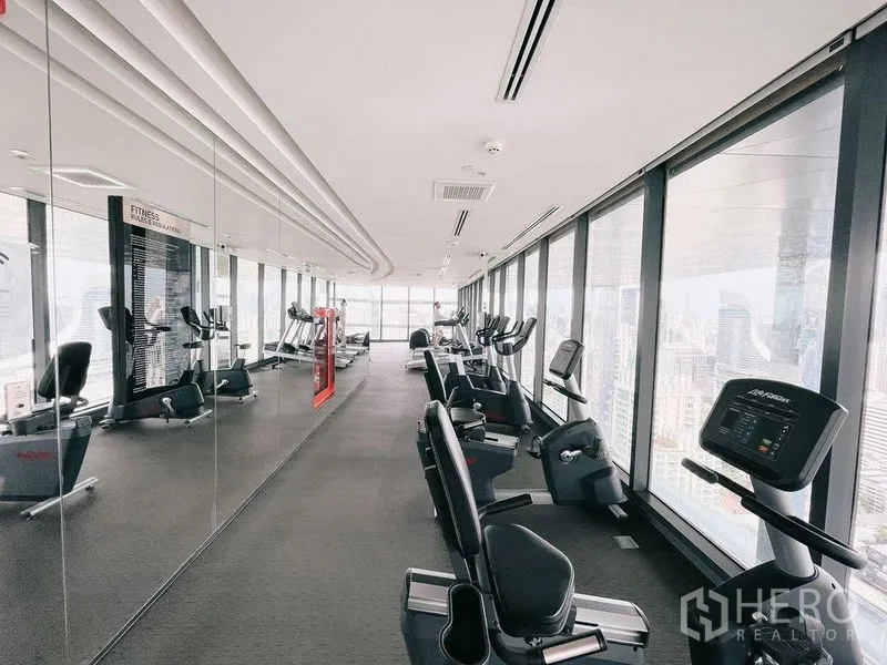 Condominium for rent in Ratchathewi, Bangkok - Sky gym with cardio machines and floor‑to‑ceiling windows overlooking Bangkok.