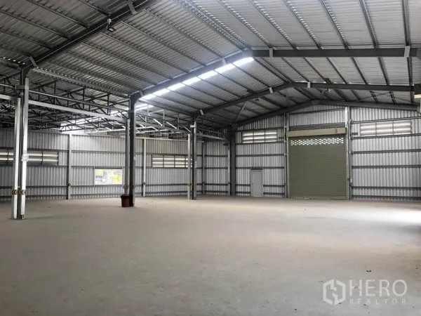 Warehouse for rent in Bang Yai, Nonthaburi - Spacious warehouse interior with high gabled steel roof, skylights and smooth concrete floor.