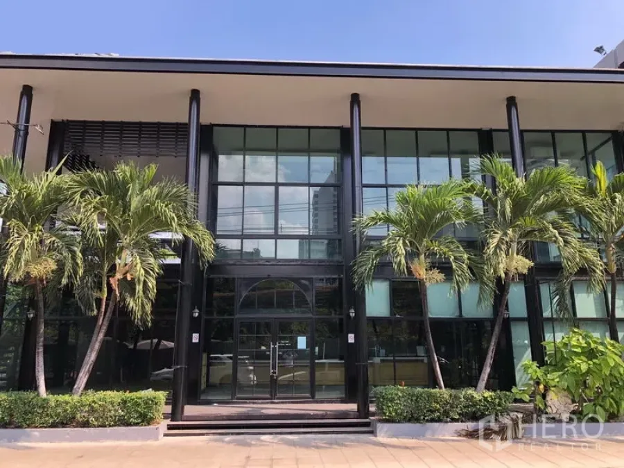 Retail Space for rent in Khlong Toei, Bangkok - Modern two-storey retail building with full-height glass facade and palm landscaping in Nana, Bangkok.