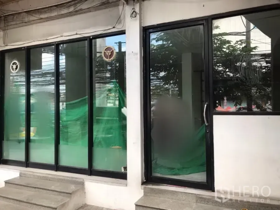 零售空间 出租在Bang Kapi, Bangkok - Bang Kapi街铺，黑色边框落地玻璃门面与台阶入口。