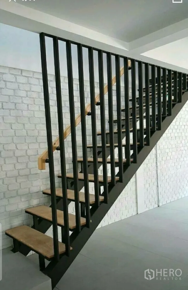 Home Office for rent in Lat Phrao, Bangkok - Industrial-style staircase with black metal rails and wooden treads against a white brick wall.
