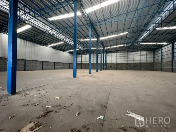 Warehouse for rent in Lat Krabang, Bangkok - Clear-span storage area with concrete floor and blue steel columns throughout.